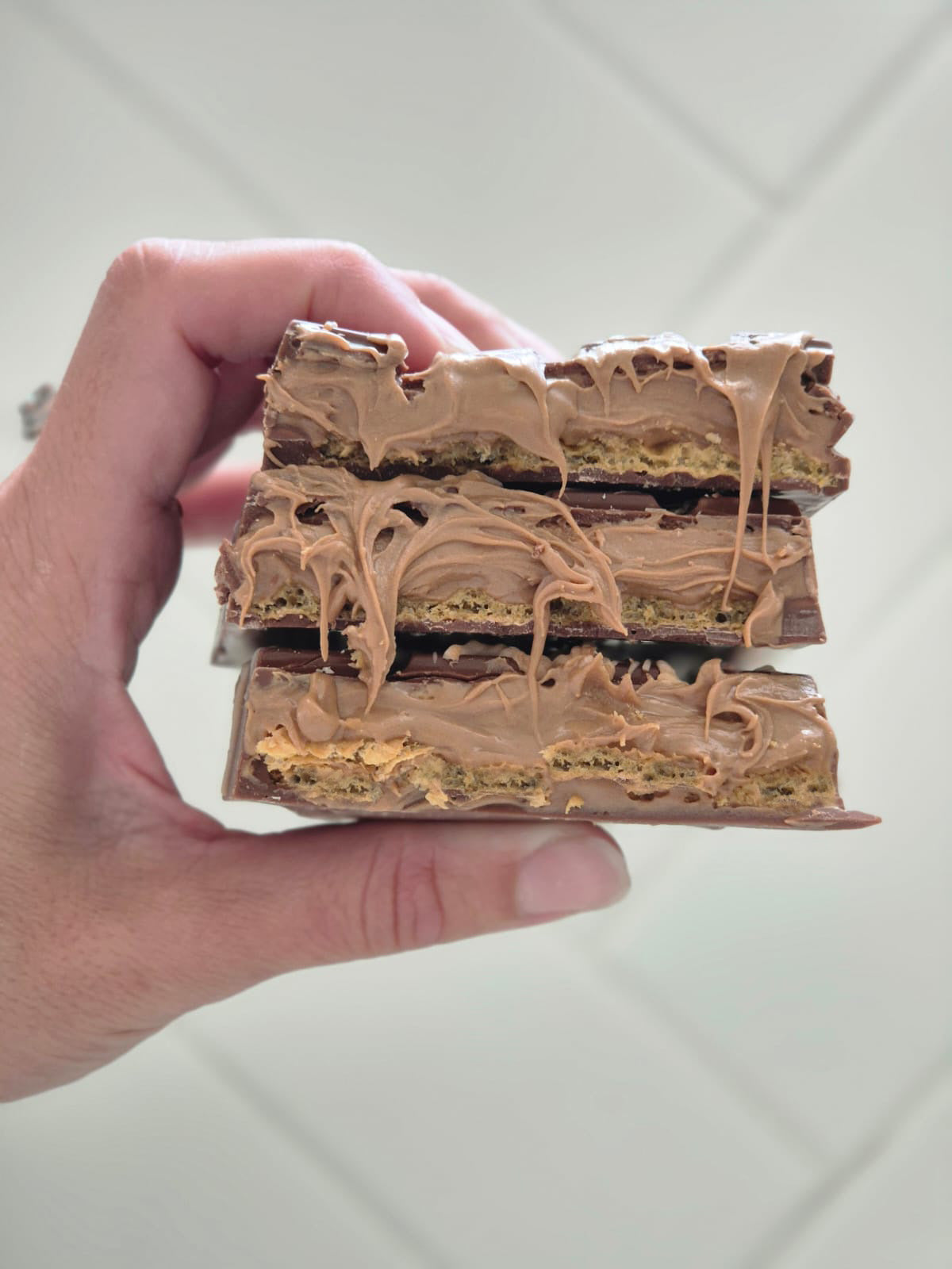 Hand Holding Opened Bueno Crispy Dubai Chocolate Bar